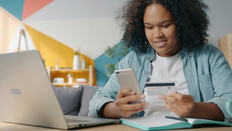 Woman shopping online with her phone and a payment card